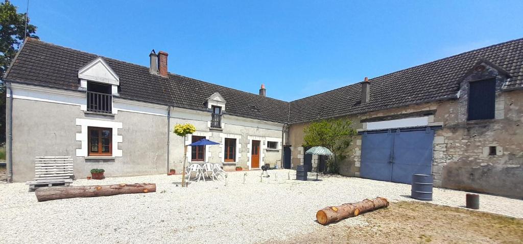 einen Innenhof eines Hauses mit einem Gebäude mit einer Garage in der Unterkunft Villa coco 9 personnes jardin proche Beauval in La Vernelle