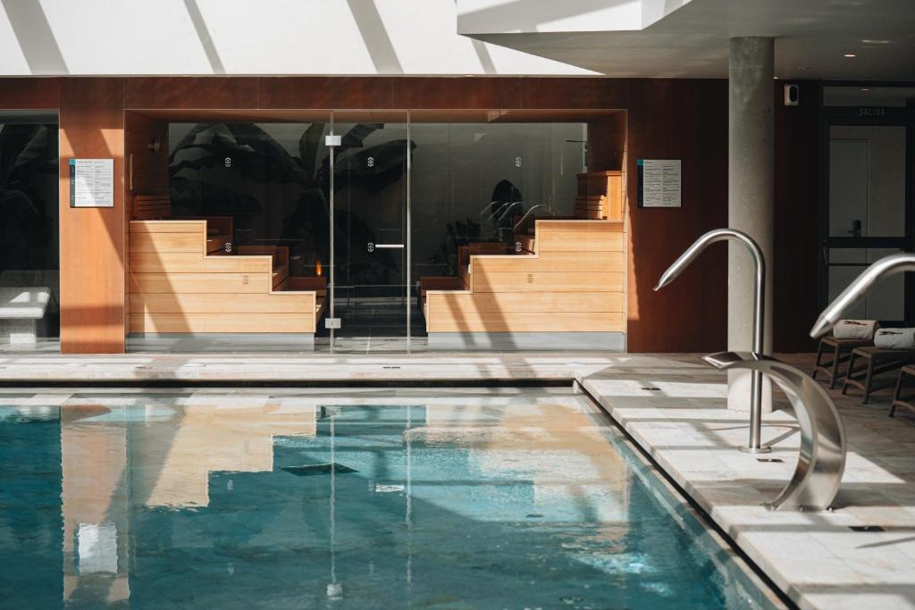 a swimming pool in front of a building with stairs at BANCAL HOTEL and SPA in San Sebastián de la Gomera