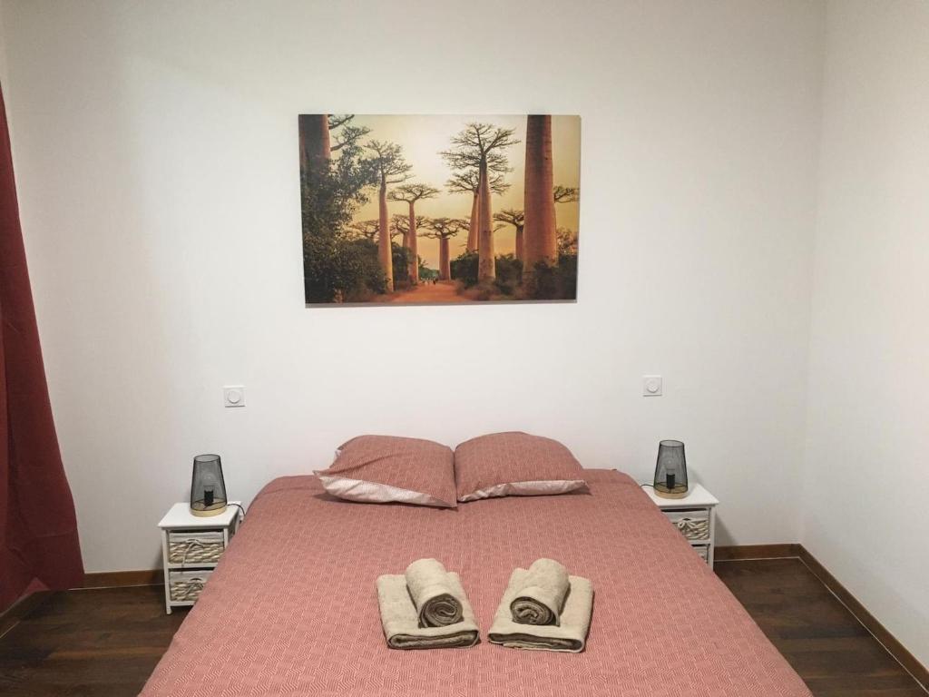 ein Schlafzimmer mit einem Bett mit zwei Hausschuhen darauf in der Unterkunft Belle Maison 8 pers Vatan centre in Vatan