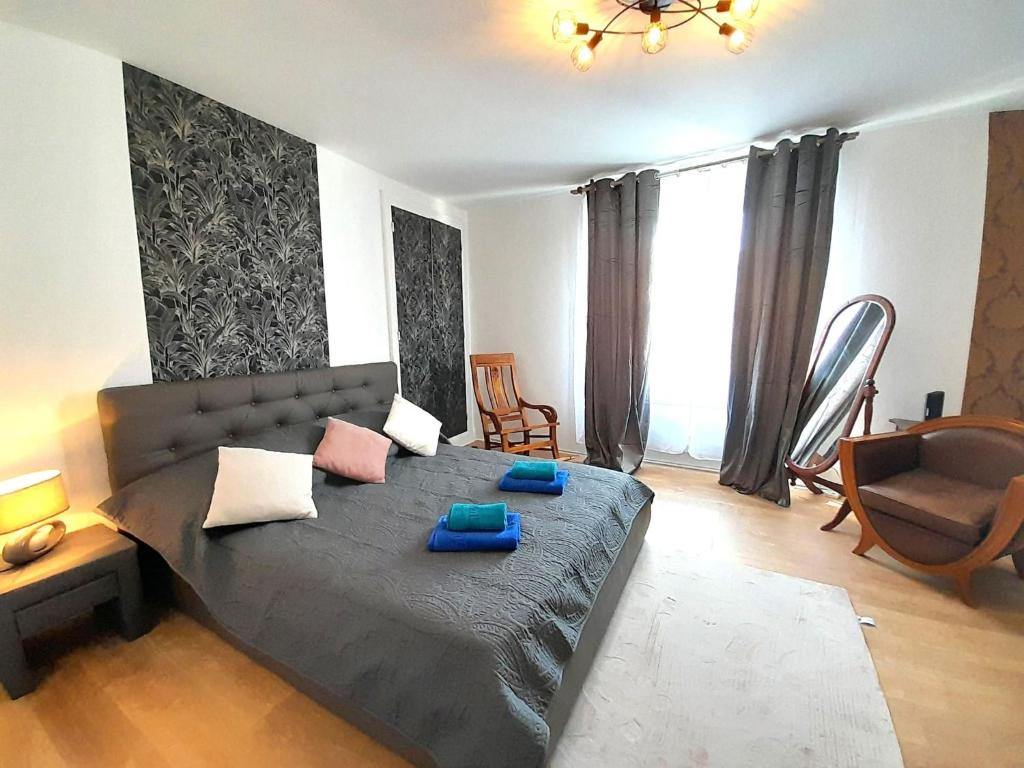 une chambre avec un grand lit avec des oreillers bleus dessus dans l'établissement Bel Appart centre ville jardin, à Châteauroux