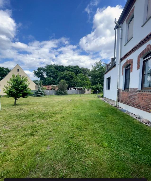 a grassy yard next to a brick building at Gästewohnung 1 Zum Stadtwald Spremberg in Spremberg