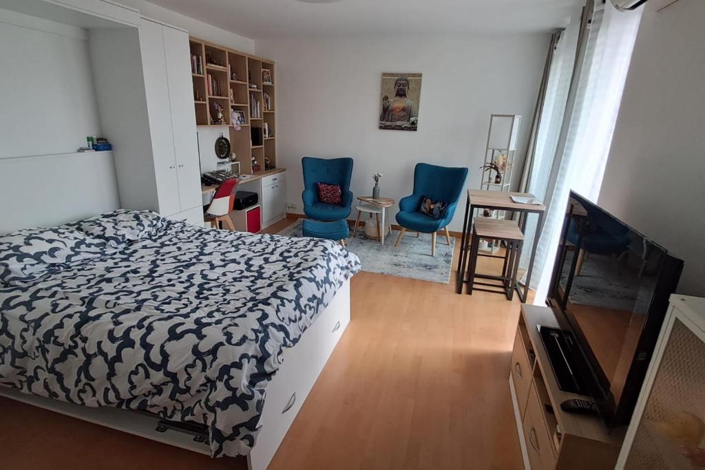 - une chambre avec un lit et deux chaises bleues dans l'établissement Charming T1 with balcony in Hyères, à Hyères