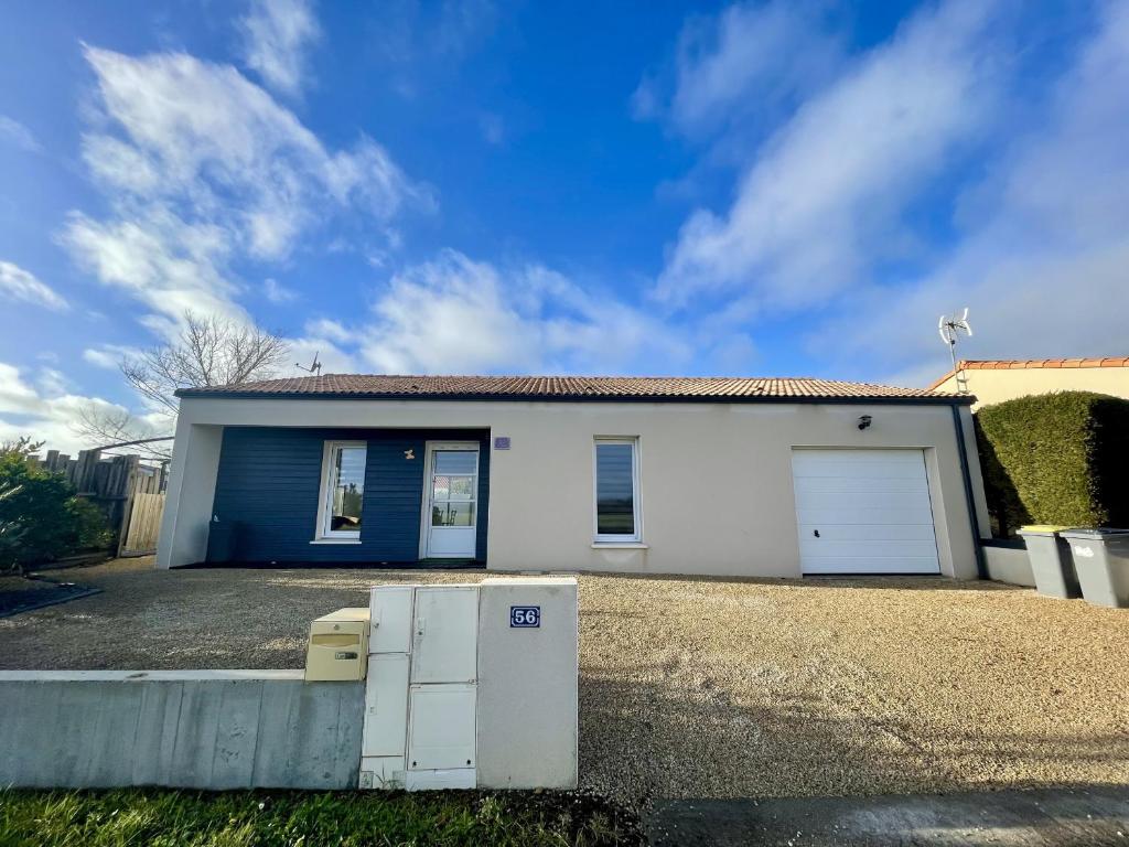 une maison blanche avec un garage bleu et blanc dans l'établissement Le Mas des lavandes, à Saint-Gilles-Croix-de-Vie