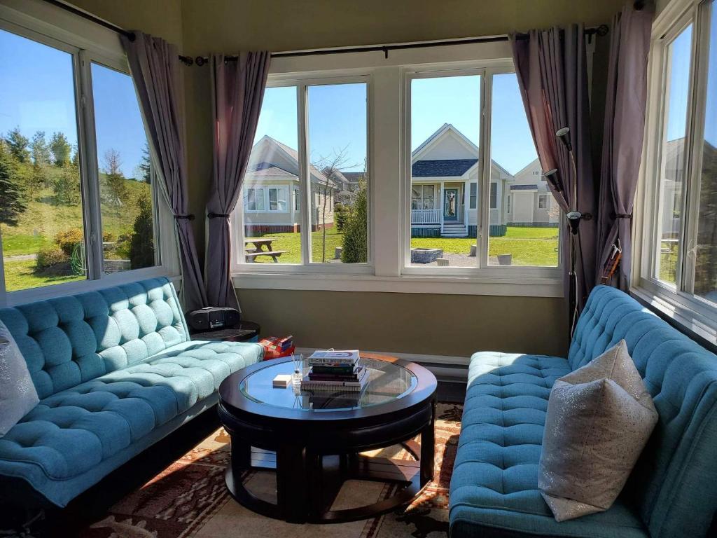 a living room with two blue couches and a table at The King Eider - 24 Meadow View in Cherry Valley
