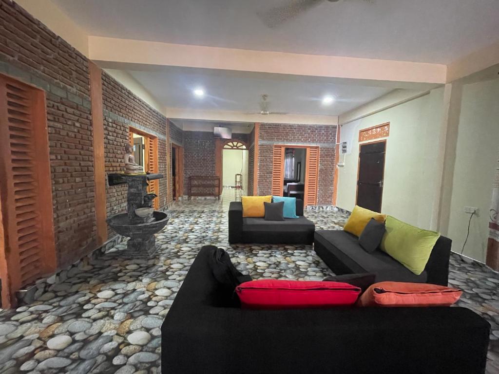a living room with two couches and a brick wall at Saa in Anuradhapura