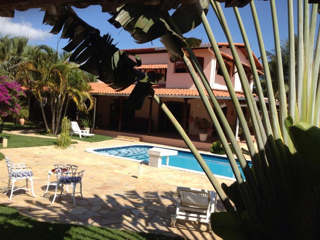 einen Hof mit Pool und ein Haus mit Palmen in der Unterkunft Casa Paraiso in Paulista