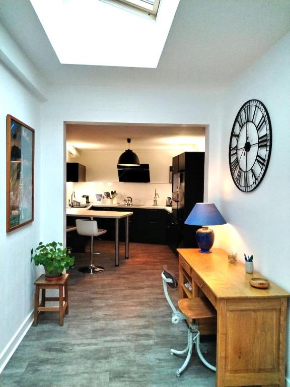 un salon avec une horloge au mur dans l'établissement Châteauroux charmante maison 2 chambres jardin, à Châteauroux