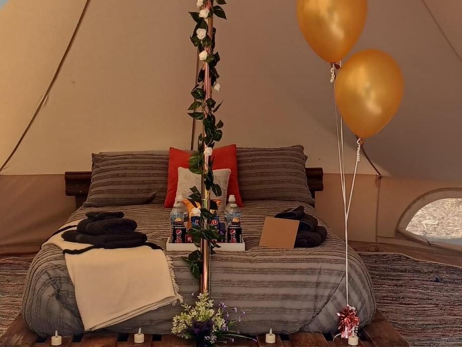 un letto in una tenda con 2 palloncini e un letto con di Fairy Cove at Rosemount Glamping a Carlingford