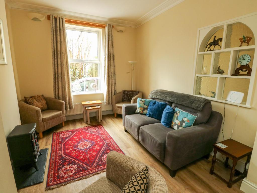 a living room with a couch and a tv at 1 Castle Row in Beaumaris