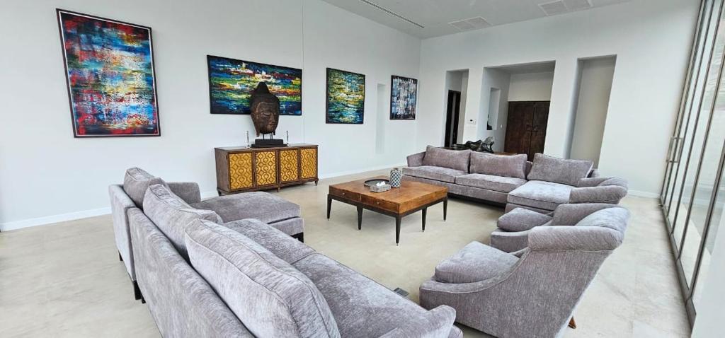 a living room with couches and a table and paintings at Villa Princess Stephanie in Kata Beach