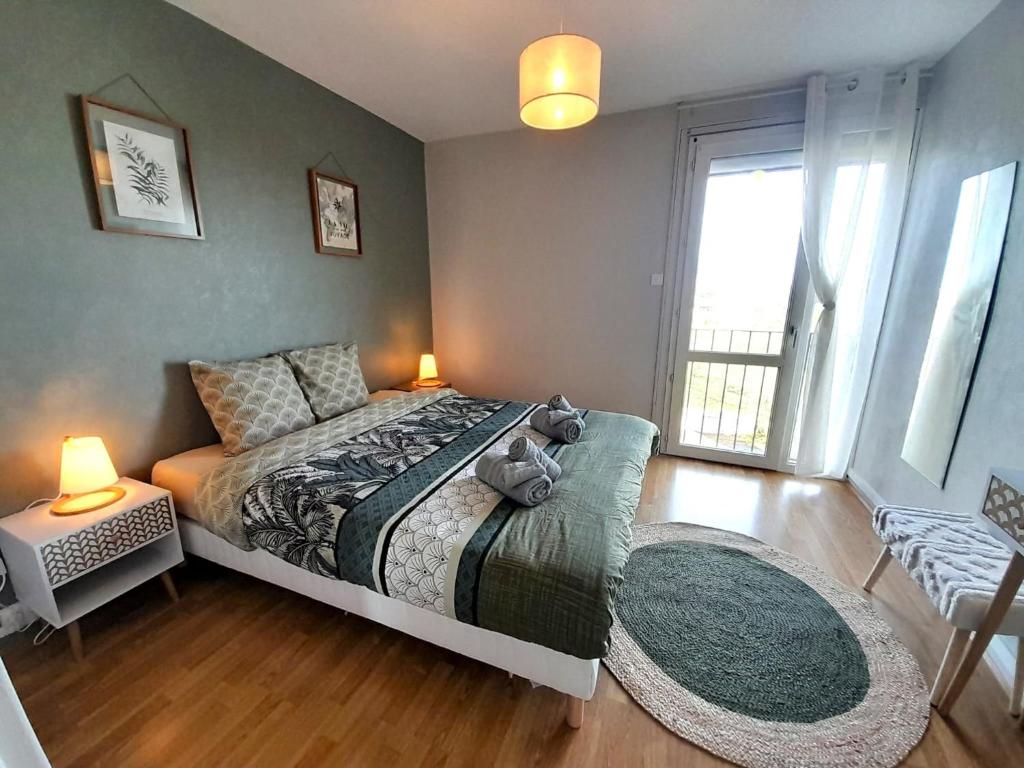 une chambre avec un lit et une grande fenêtre dans l'établissement Ravissant appart-2chb-3 lits-wifi, à Châteauroux