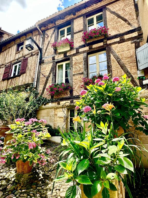 une maison avec beaucoup de fleurs devant elle dans l'établissement Le Logis Plantagenêt, à Bergerac