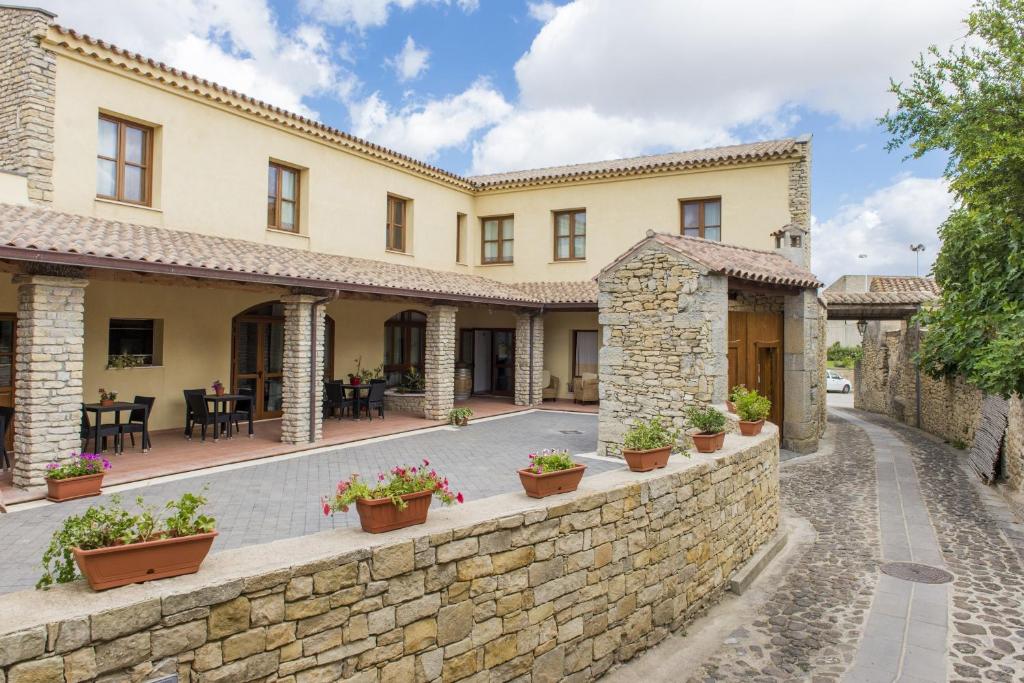 an exterior view of a building with a stone wall at Albergo Diffuso Il Mandorlo in Baressa