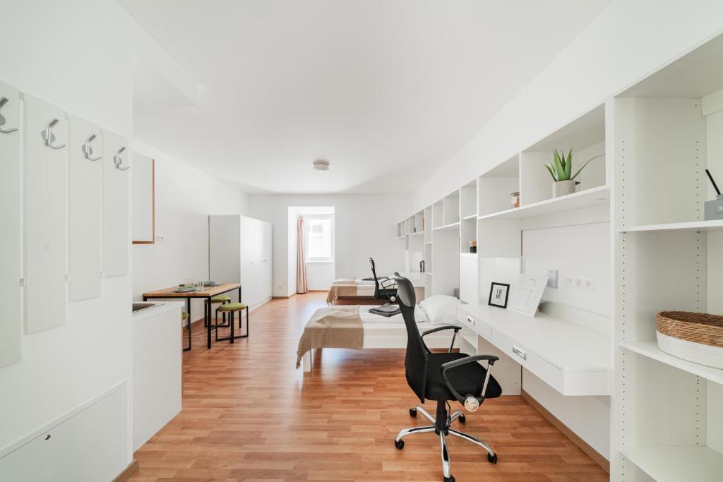 a white room with a desk and a chair in it at Central Urban Studio in Wiener Neustadt