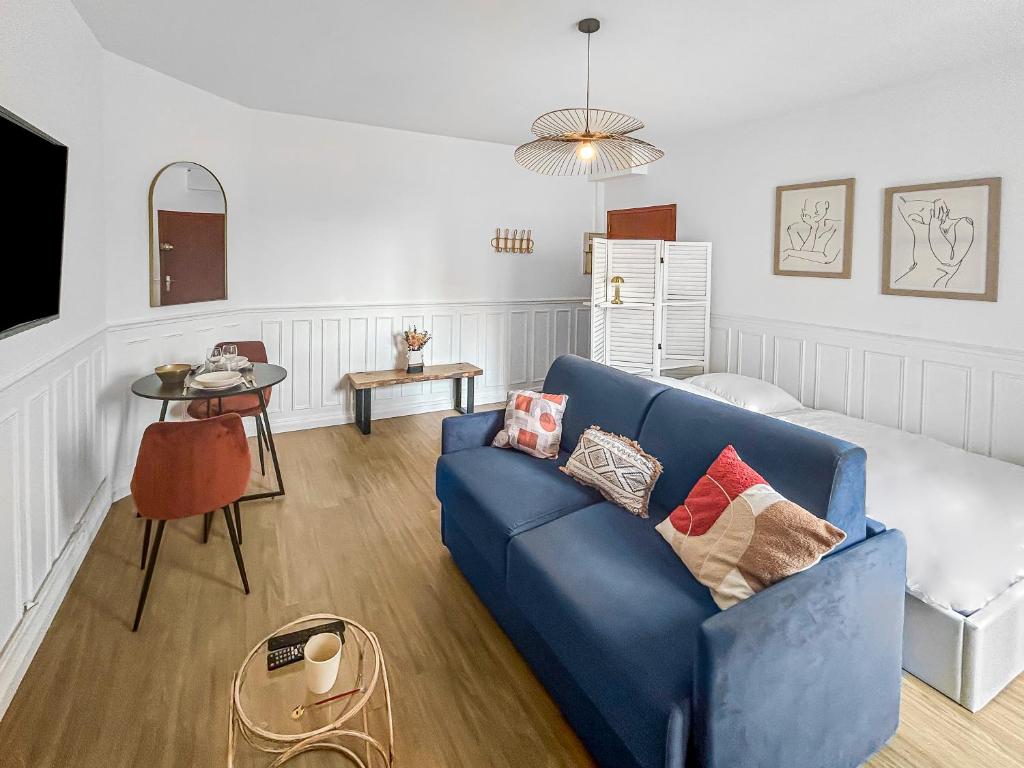 un salon avec un canapé bleu et une table dans l'établissement Évasion Rémoise, à Reims