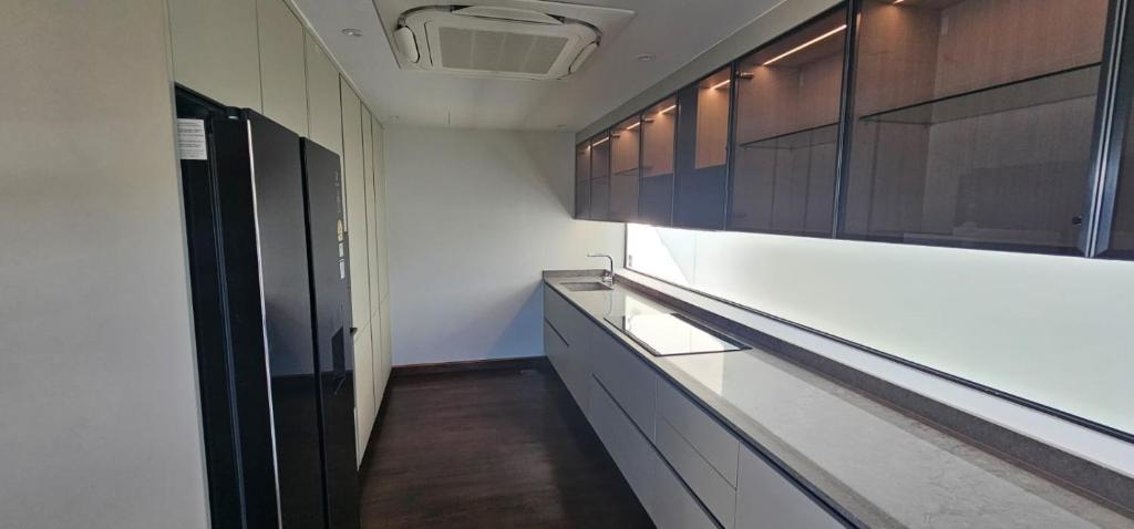 a kitchen with white walls and wooden cabinets at Villa Princess Stephanie in Kata Beach