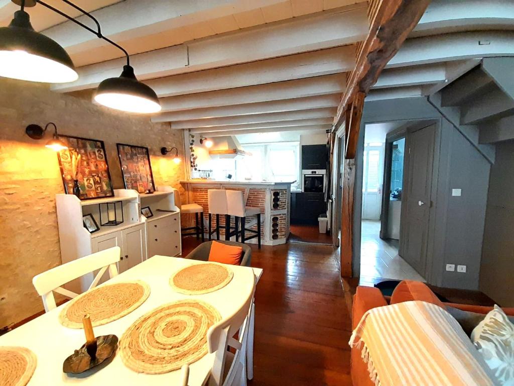 una cucina e una sala da pranzo con tavolo e sedie di Châteauroux centre superbe appart duplex terrasse a Châteauroux