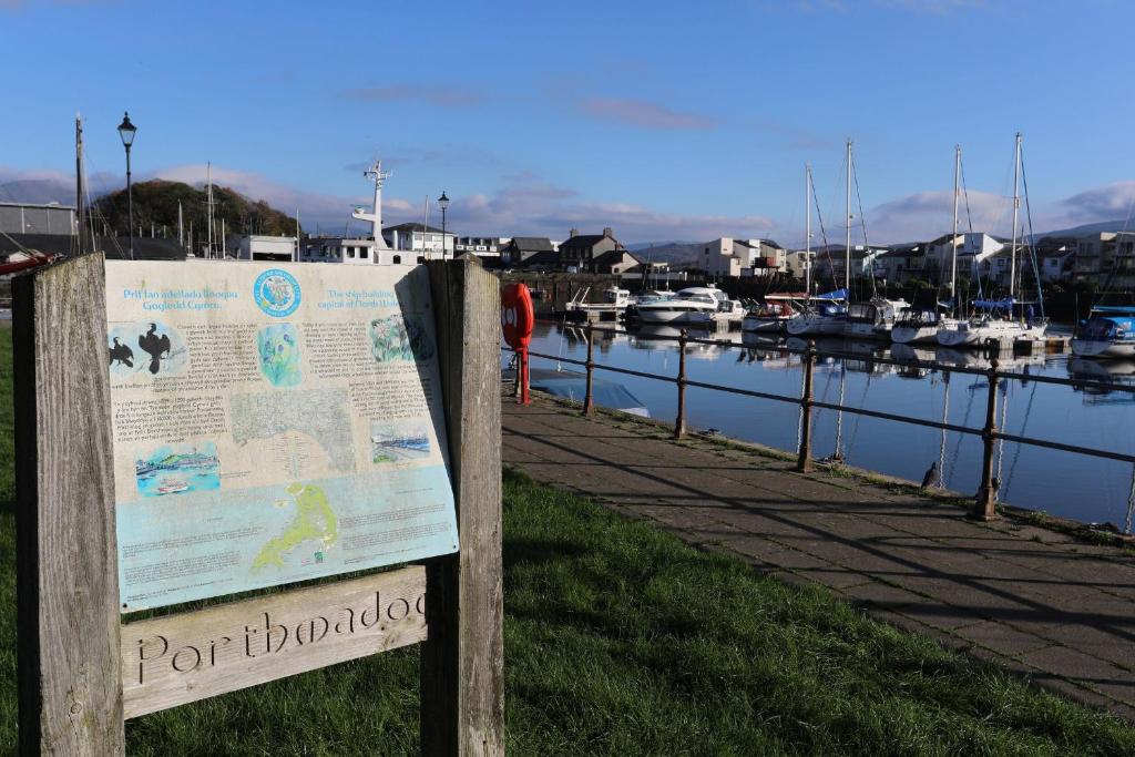 a sign next to a marina with boats in the water at 59A South Snowdon Wharf in Porthmadog