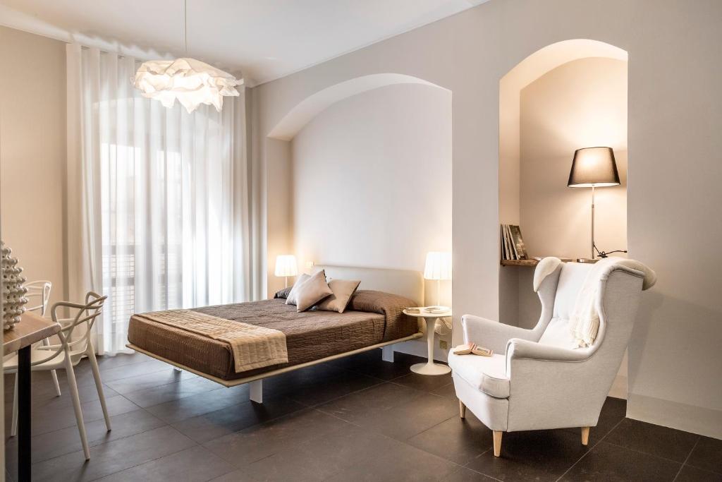 a bedroom with a bed and a chair at B&B Vicere Speciale in Noto