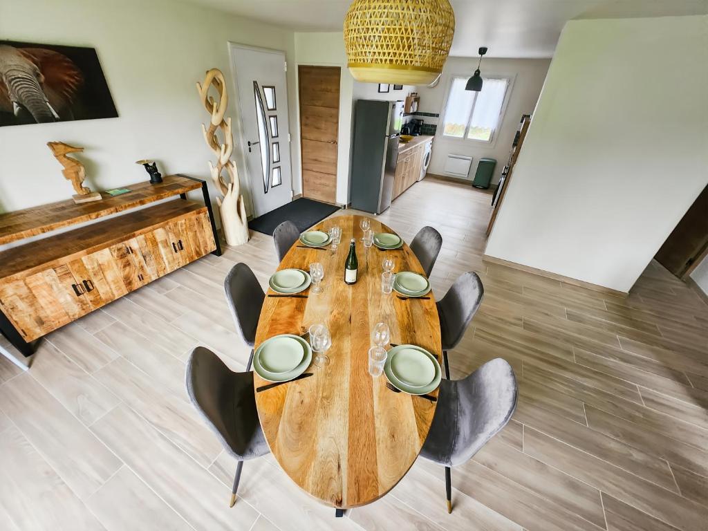 une grande table en bois et des chaises dans une pièce dans l'établissement Villa L'Isachrist, Calme, Confort, 20' Disneyland, à Maisoncelles-en-Brie