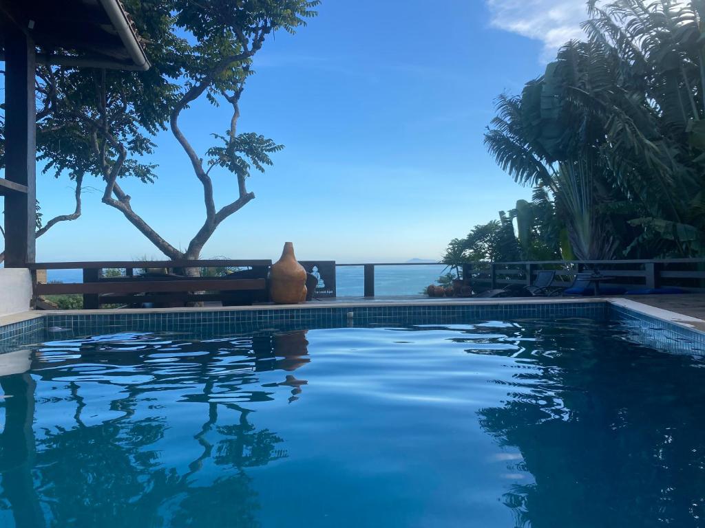 a swimming pool with a view of the ocean at Maravilha in Búzios