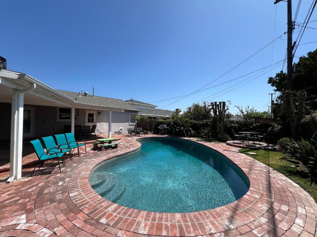a swimming pool with blue chairs and a patio at Destination #13 in Anaheim