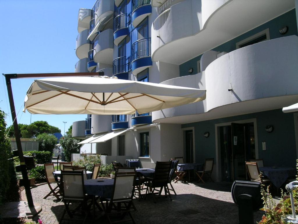 a table and chairs with an umbrella in front of a building at Meubleterme in Grado