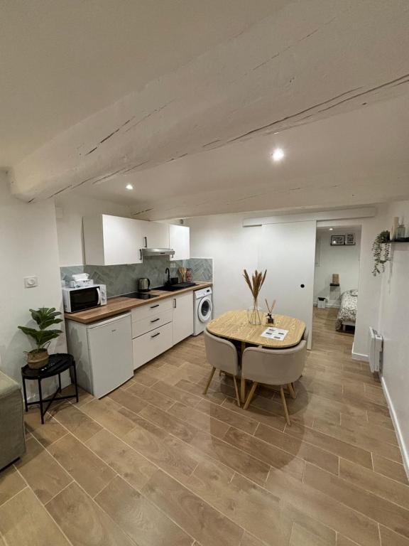une cuisine avec une table et une cuisine avec une cuisinière dans l'établissement Appartement cosy centre historique Avignon, à Avignon