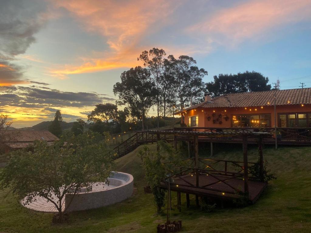 a view of a house with a sunset in the background at Casa Brandão Pousada in Bueno Brandão