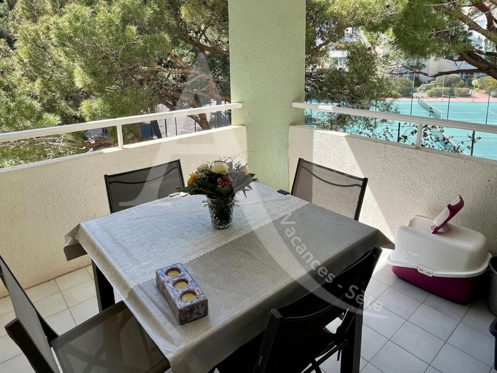 d'une table et de chaises sur un balcon avec vue sur la piscine. dans l'établissement Quartier plage 1 chambre Parking Climatisation Internet, à Sète