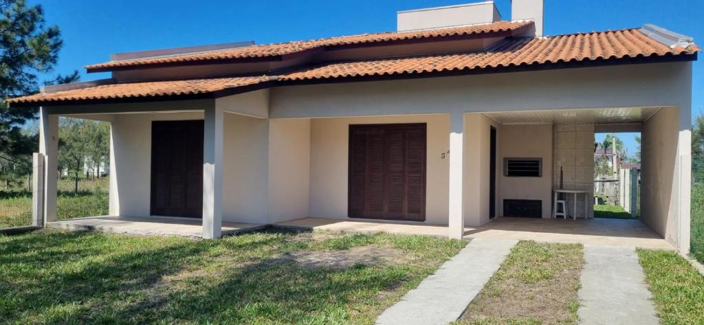 a small house is shown with a yard at stone house in Balneário Gaivotas