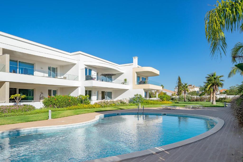 ein großes Haus mit einem davorliegenden Swimmingpool in der Unterkunft Ancora Apt do Mos in Lagos