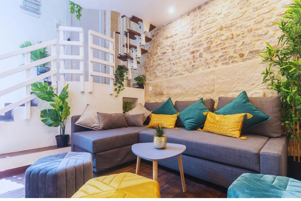un salon avec un canapé et un mur de briques dans l'établissement Duplex Parisien charmant métro13, à Paris