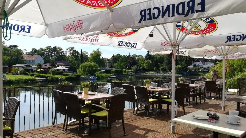 an outdoor patio with tables and chairs and umbrellas at Havelpension in Rathenow