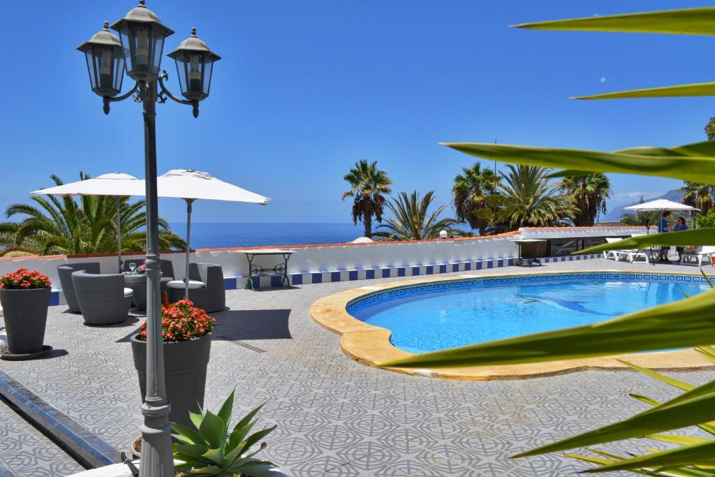 einen Swimmingpool mit einer Lichtstange und dem Meer in der Unterkunft Casa Business Finca Alcala in Alcalá