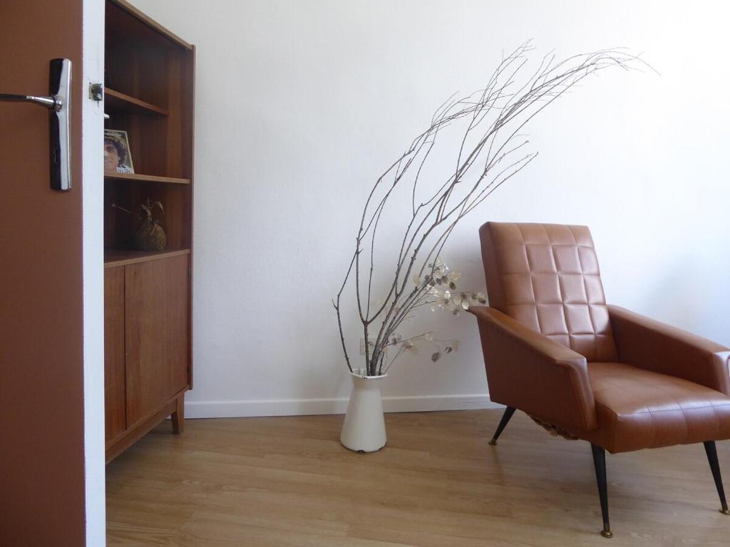 a chair and a vase with flowers in a room at La casa venta in Tournon-sur-Rhône