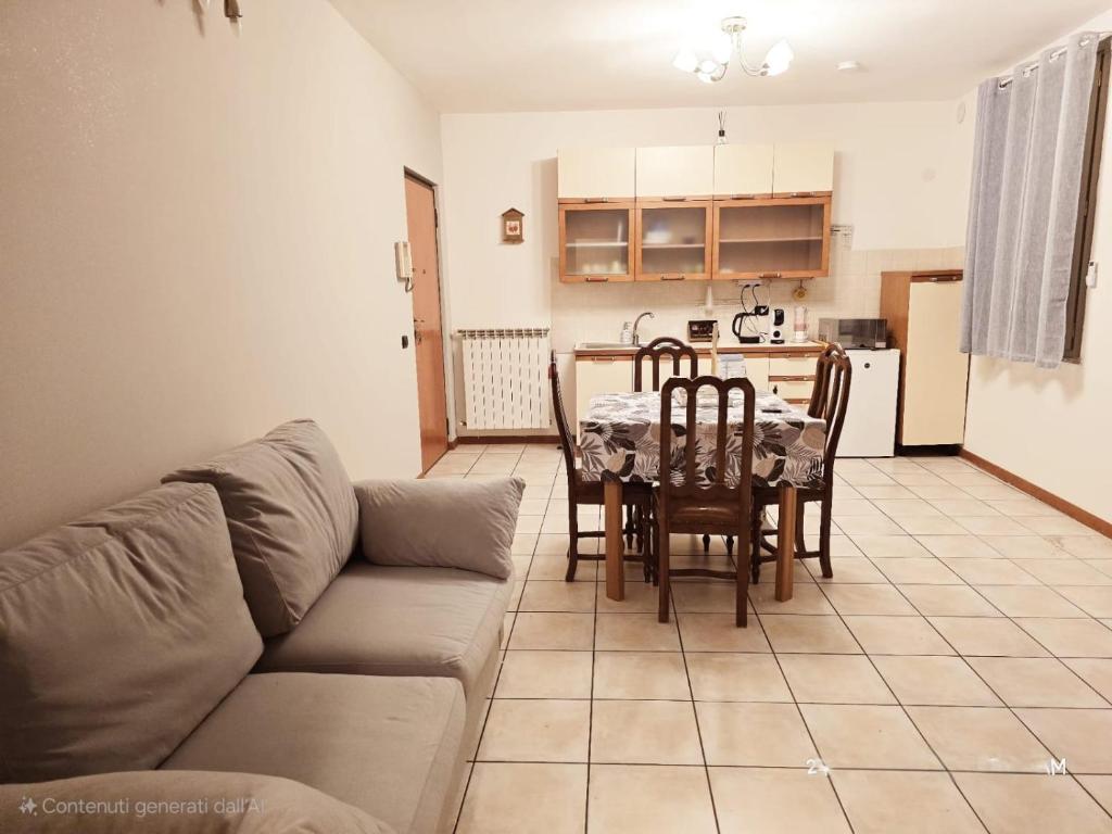 a living room with a couch and a table and a kitchen at La Corte Guesthouse in Cornate dʼAdda