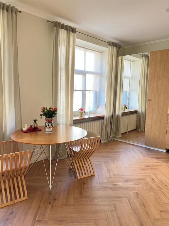 une salle à manger avec une table et des chaises et une fenêtre dans l'établissement Brand new apartment in a historical location, à Riga