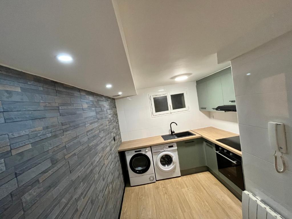 une petite cuisine avec un lave-linge et un sèche-linge. dans l'établissement Appartement dans petite résidence très calme, à Drancy
