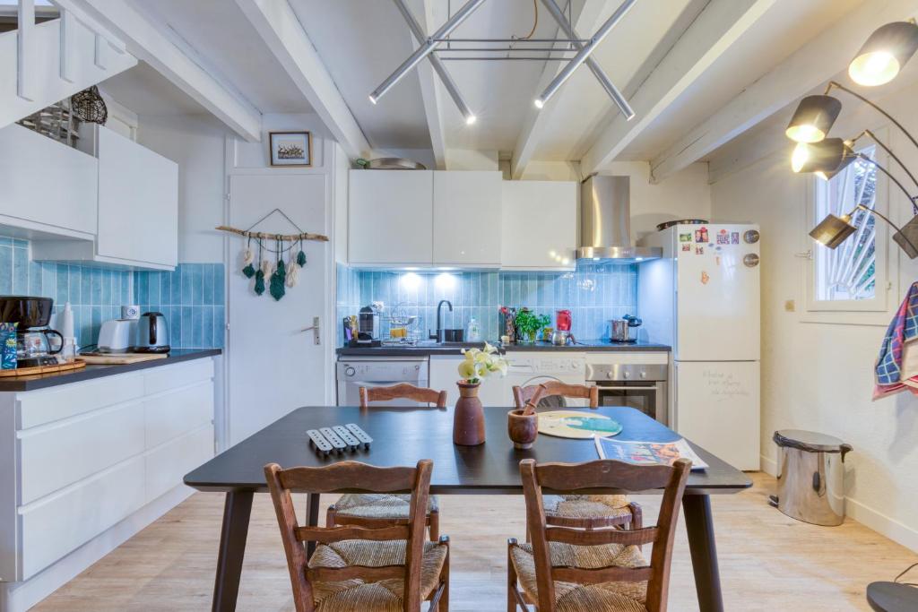 a kitchen with a table and chairs and a refrigerator at Maison pour 6 entre Vignes et Mer in Marseillan