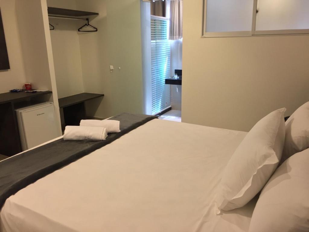 a white bed in a room with a window at Scenarium Hotel in Recife