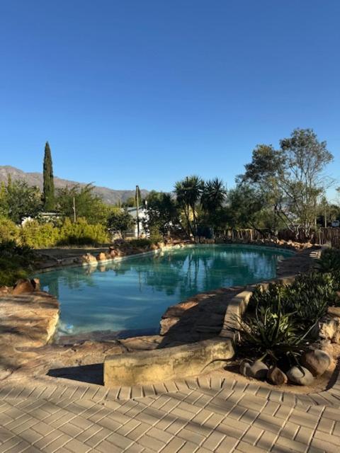 a swimming pool with blue water in a park at Flyers' Lodge in Porterville
