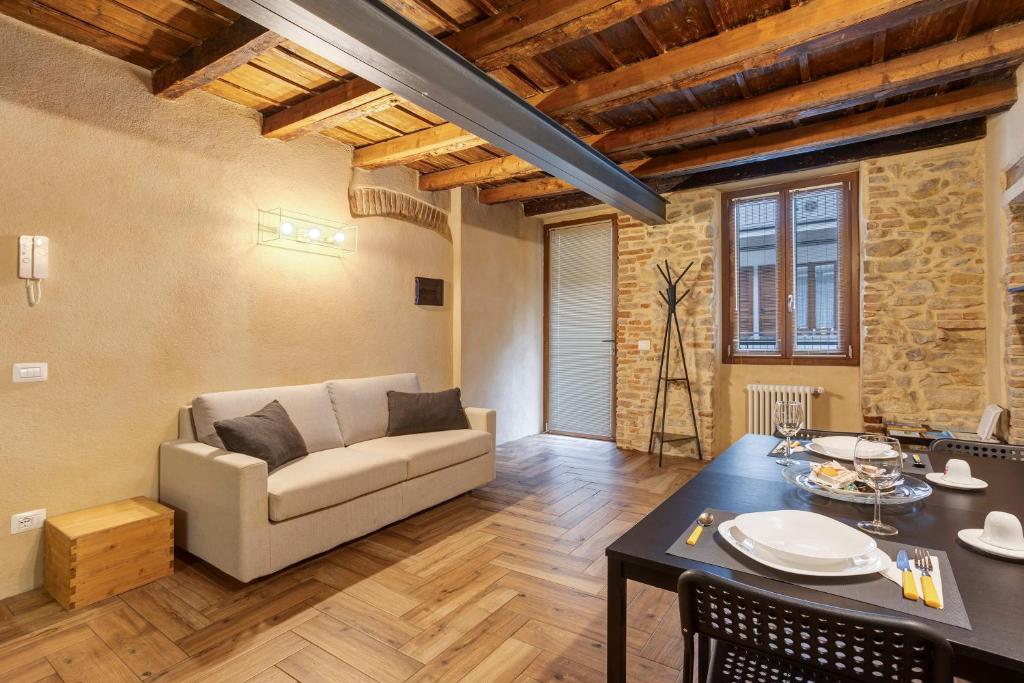una sala de estar con un sofá y una mesa en Maison Le Chic, en Bérgamo