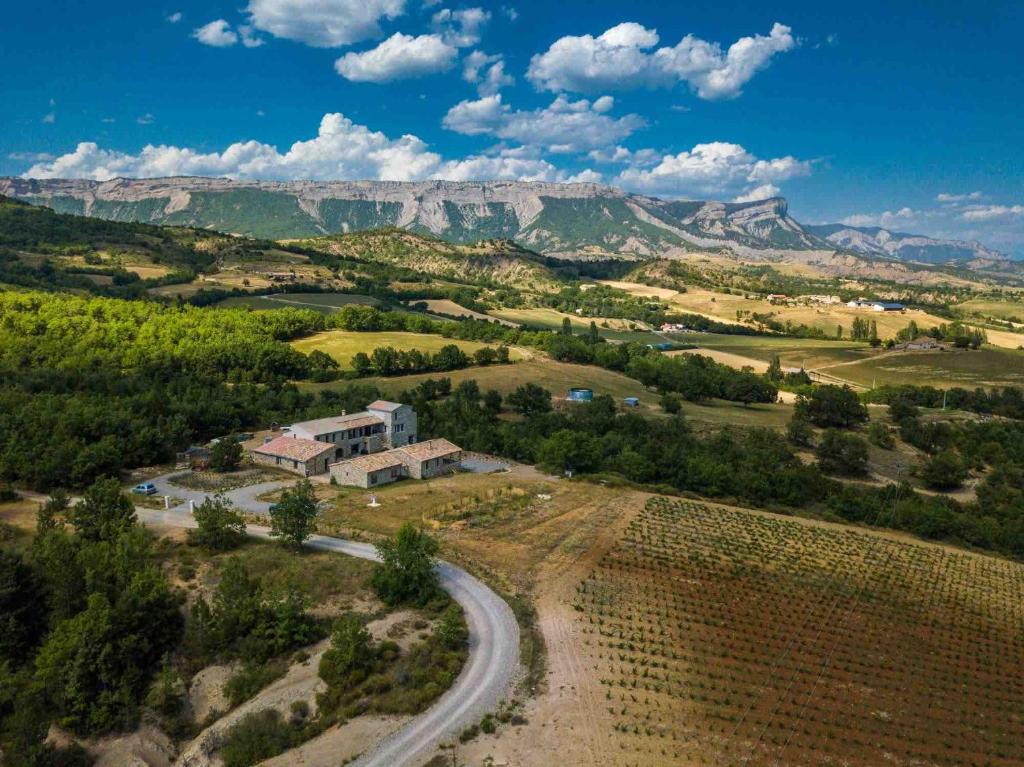 une vue aérienne sur une ferme avec des montagnes en arrière-plan dans l'établissement Maison Time-out, à Villevieille