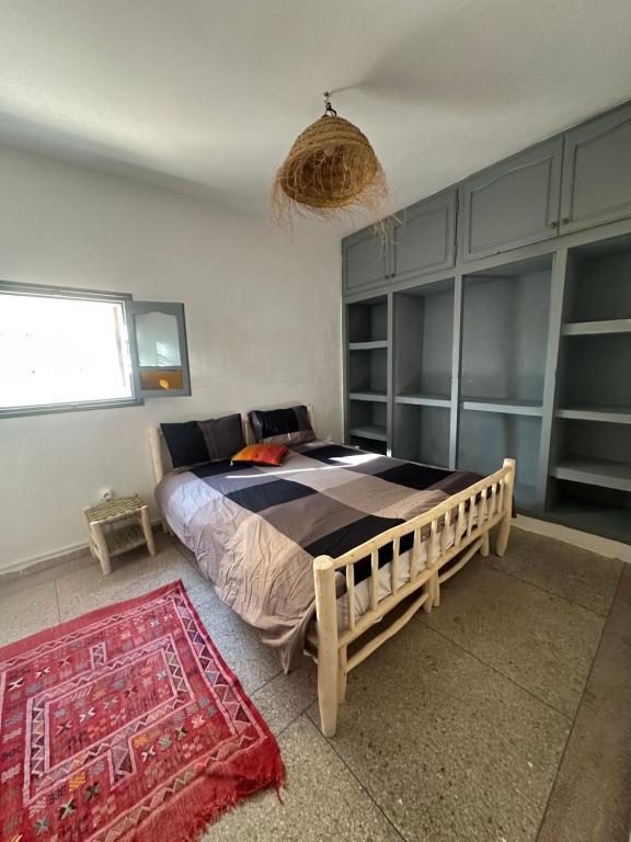 una camera con un letto e un tappeto di DAR SANAE SURF ad Aourir