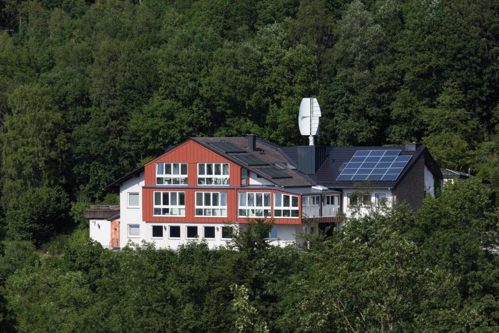 ein Haus mit Sonnenkollektoren auf einem Hügel in der Unterkunft Kurmittelhaus Wagner in Willingen