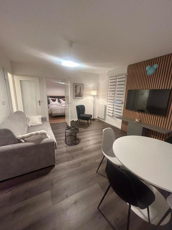 un salon avec un canapé et une table dans l'établissement Central Disney apartment, à Chessy