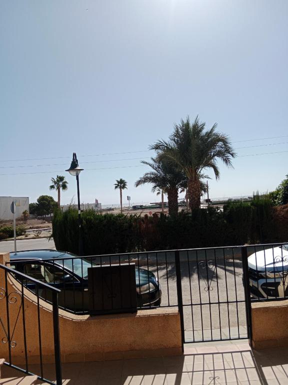 a balcony with a fence and palm trees at Sol y playa in Palomares