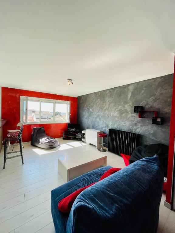 - un salon avec un canapé bleu et des murs rouges dans l'établissement Chambre chez l'habitant ou Homestay dans le quartier de BONHOURE, à Toulouse
