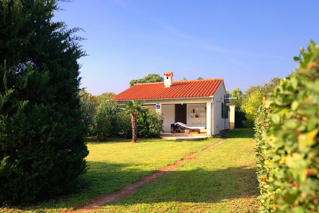 a small white house with a red roof at Adriatic Vacation House in Ližnjan
